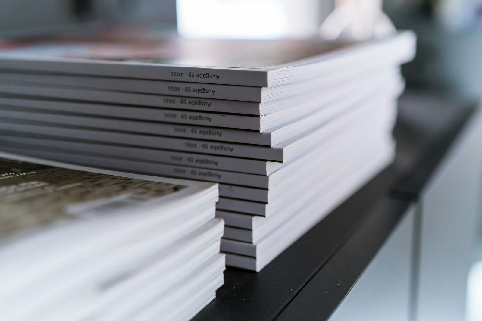 Stack of white printed booklets on a dark table
