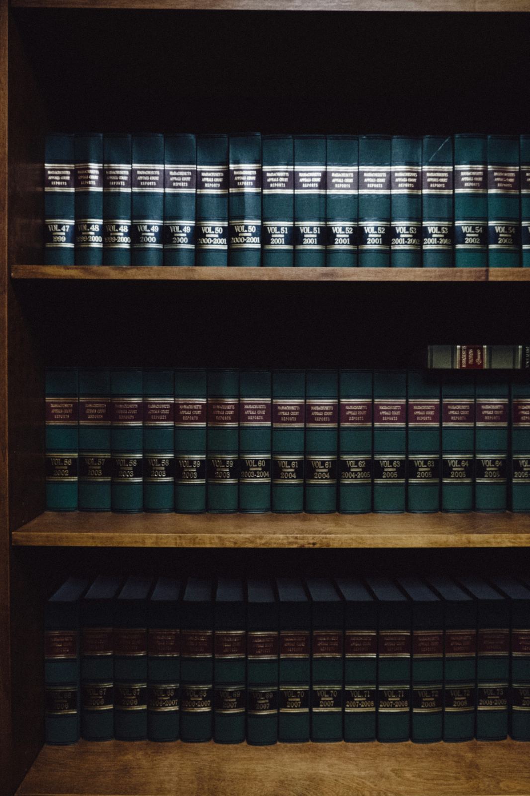 Rows of legal reference books on a wooden shelf