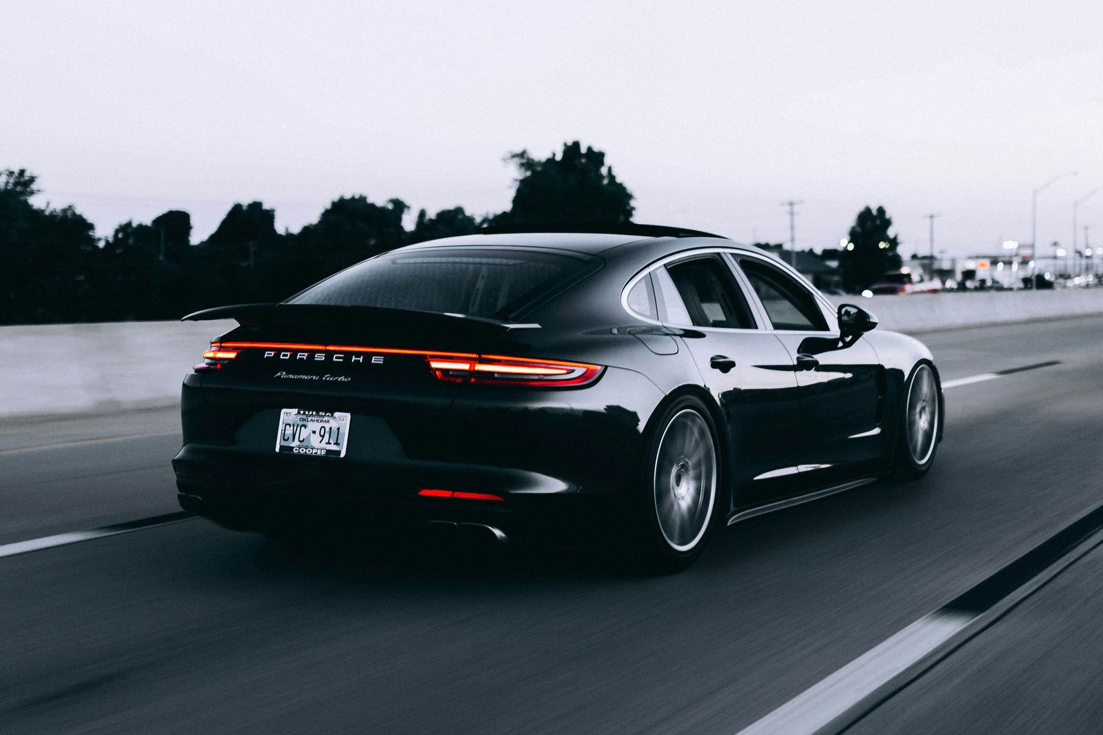 Black sedan car running on a road at dusk