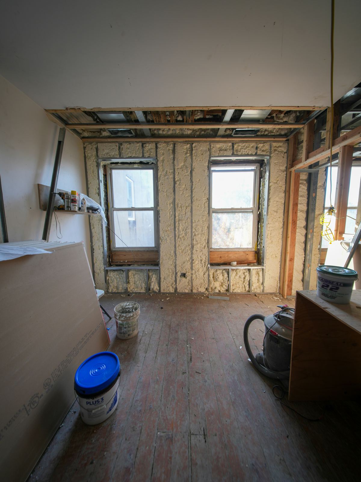 Interior room under construction with exposed walls and windows